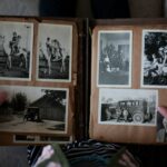 person opening photo album displaying grayscale photos