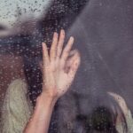 woman touch rainy glass